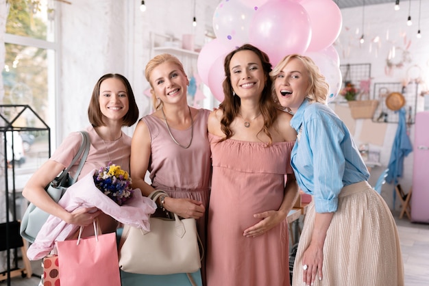 Femmes qui réussissent. Entreprise de quatre belles femmes réussies faisant des photos pendant la douche de bébé