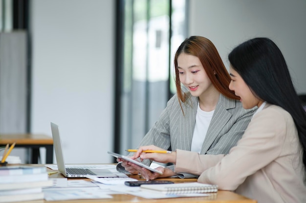 Les femmes qui travaillent discutent de leur travail et planifient de nouveaux projets d'affaires en échangeant des idées avec leurs collègues.