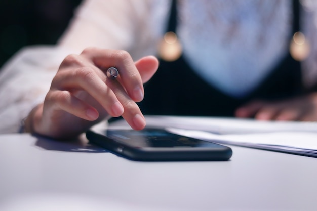 Les femmes qui utilisent un téléphone intelligent travaillent au milieu de la nuit.