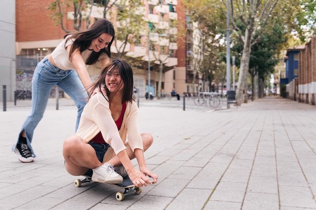 Femmes riant et jouant avec une planche à roulettes