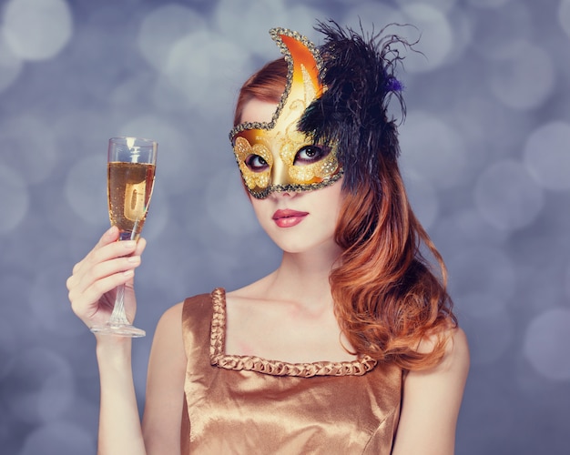 Femmes rousses en masque avec du champagne