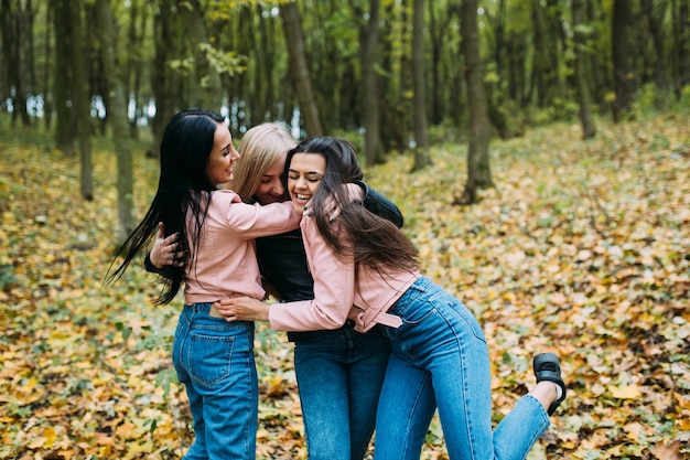 Femmes s&#39;amusant dans les feuilles d&#39;automne