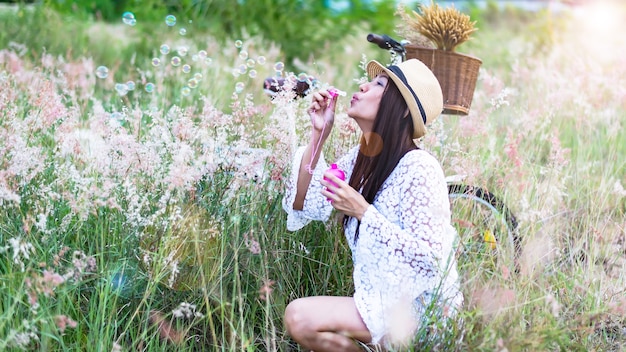 Les femmes se détendent et aiment jouer des bulles dans la prairie de fleurs