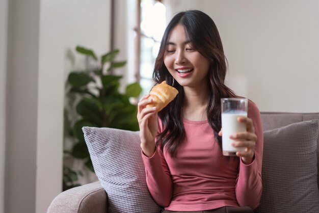 Les femmes se divertissent sur le canapé pour boire du lait et manger du pain avec un repas sain dans un mode de vie à la maison