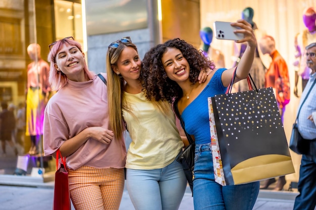 Des femmes se font un selfie en portant des sacs d'achat dans un centre commercial
