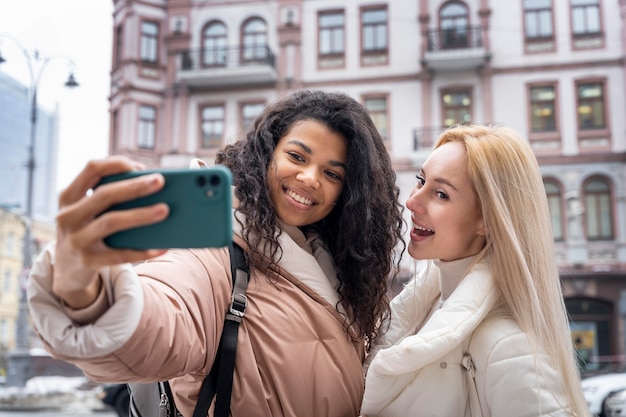 Femmes smiley à coup moyen prenant selfie