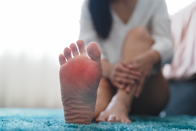 Les femmes souffrant de douleur à la cheville touchent son concept de soins de santé et de médecine douloureux au pied
