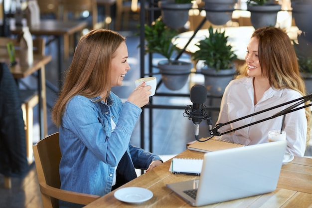 Femmes souriantes communiquant avec un café savoureux au café