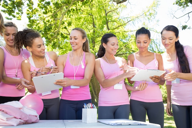 Des femmes souriantes organisent un événement pour la sensibilisation au cancer du sein