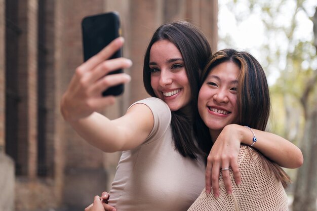 Femmes souriantes et s'amusant en prenant un selfie