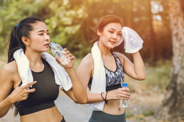 Femmes sportives en bonne santé assoiffées d'eau potable pendant l'exercice pendant la saison estivale chaude