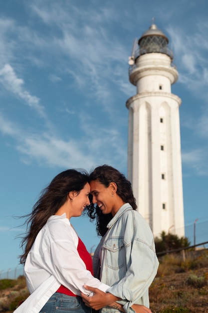 Des femmes de taille moyenne posent avec un phare.