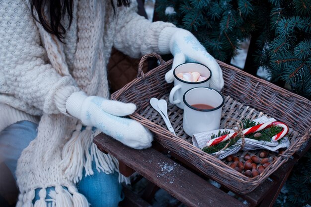 Femmes tenant une tasse de cacao dans un panier en osier sur une table en bois