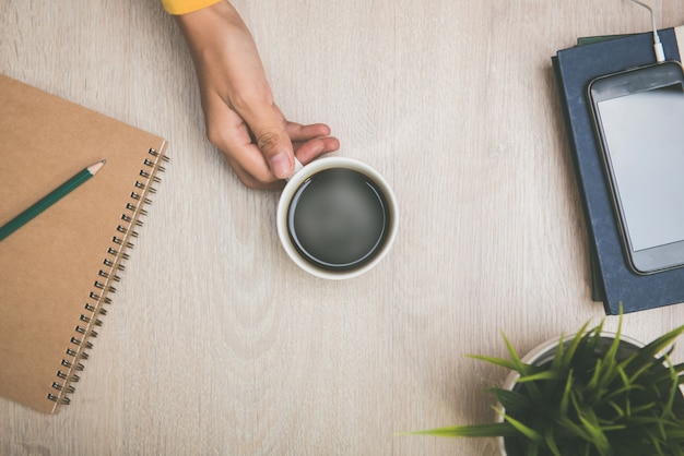 Femmes tenant une tasse de café chaud tout en travaillant au bureau