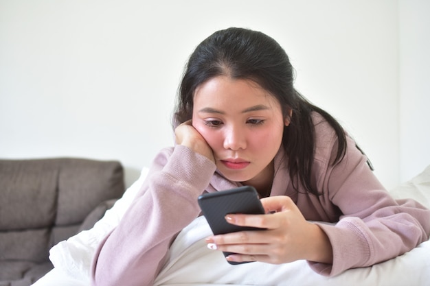 Femmes tenant et utilisant un téléphone mobile intelligent pour faire des achats en ligne par la technologie Internet