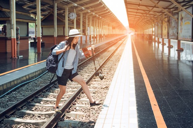 Les femmes transportant des bagages et des caméras prennent un raccourci vers le chemin de fer.