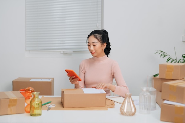 Femmes travaillant à la pige et emballant des produits de livraison de boîtes aux clients Commandés en ligne