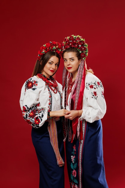 Femmes ukrainiennes en vêtements ethniques traditionnels et couronne rouge florale sur fond de studio viva magenta Robe nationale brodée appelez vyshyvanka Priez pour l'Ukraine