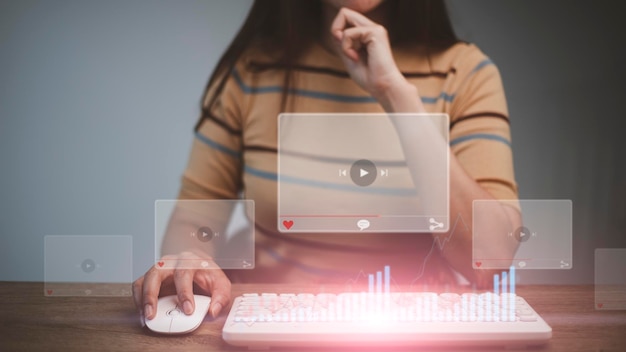 Femmes utilisant la souris et le clavier pour diffuser en ligne, regarder des vidéos sur Internet, un concert en direct, un spectacle ou un didacticiel