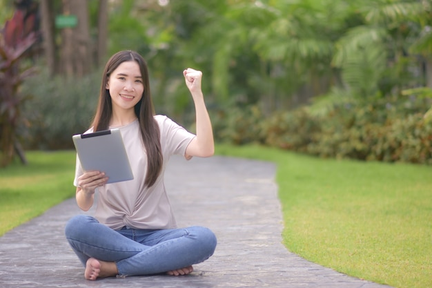 Les femmes utilisent les tablettes en ligne assis parc de la ville