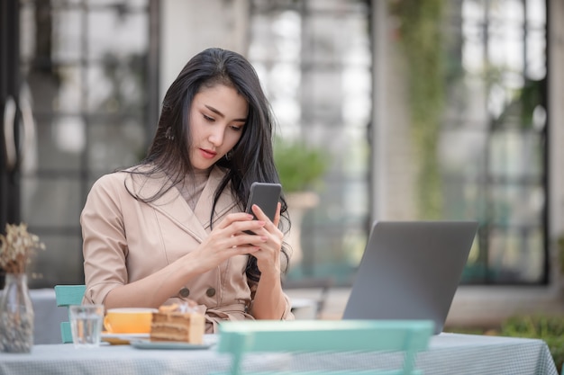 Femmes vérifiant les messes sur smartphone dans le jardin