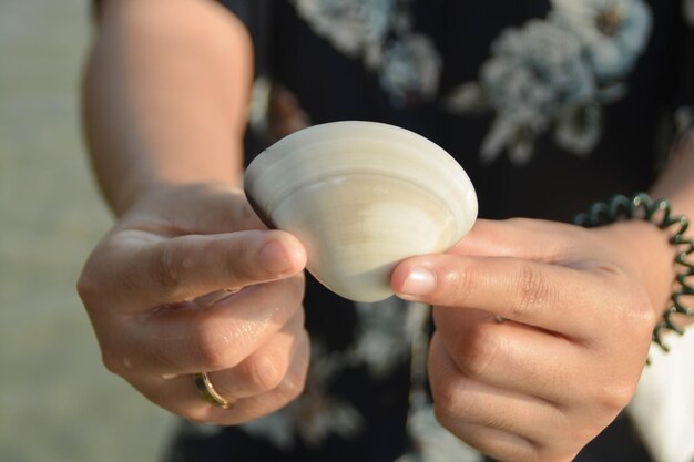 Femmes vêtues d'une robe bleue attrapant une coquille blanche