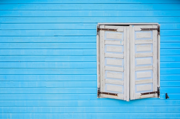 Fenêtre en bois blanc sur mur bleu