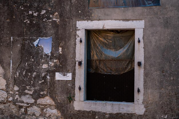 Photo fenêtre cassée dans un vieux bâtiment battu et volé dans le vieux bâtiment historique de la ville