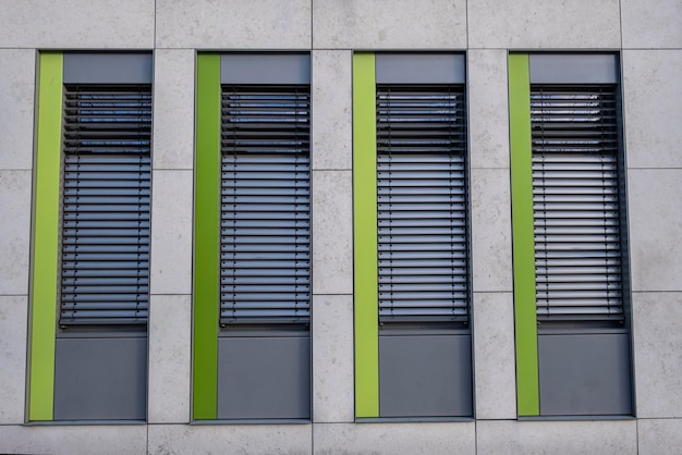 Une fenêtre grise et verte avec des stores verts