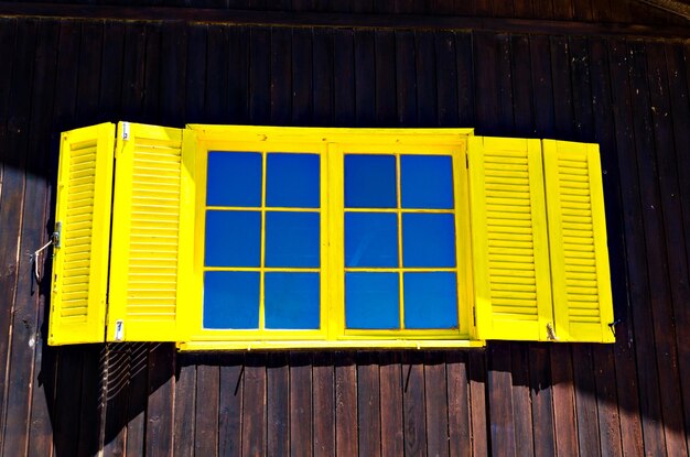 Fenêtre jaune sur mur en bois, Algarve, Portugal.