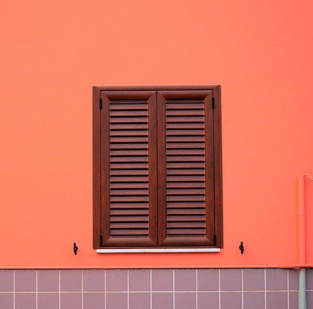 Fenêtre marron dans un mur orange et gris