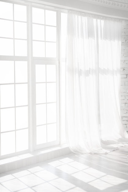 Fenêtre rétroéclairée avec des rideaux blancs dans une pièce vide. Intérieur abstrait