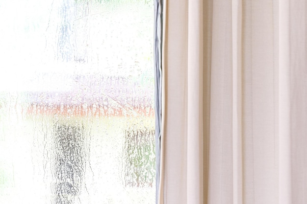 Une fenêtre avec un rideau qui dit 'pluie' dessus