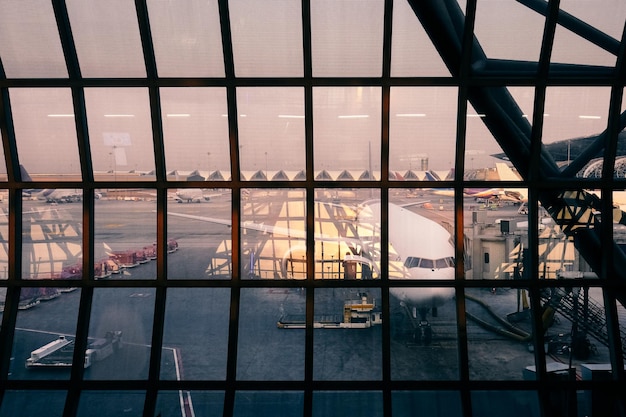 Fenêtre en verre à l'aéroport avec un avion en arrière-plan