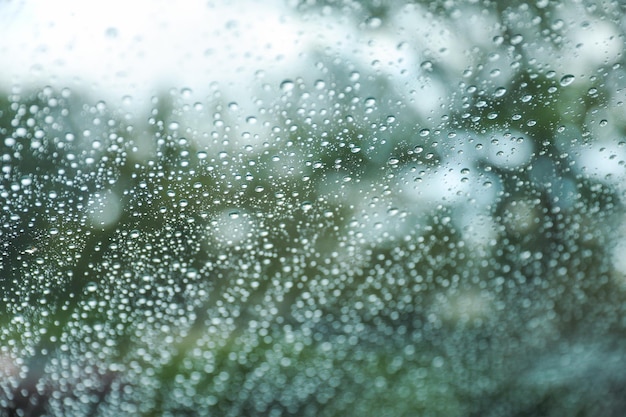 La fenêtre de la voiture couverte de gouttes de pluie symbolise la beauté et la tranquillité de la nature.