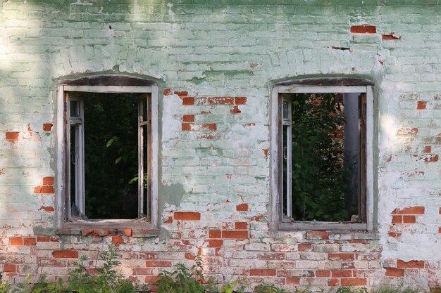 Fenêtres cassées d'une maison en brique abandonnée
