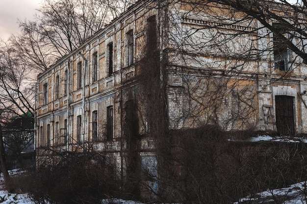 Fenêtres cassées sombres dans une maison abandonnée Vieille maison en brique en ruine