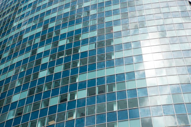 Fenêtres en verre sur l'architecture moderne de gratte-ciel de bâtiment comme fond vitreux de façade bleue