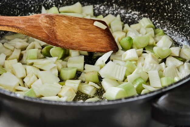 Le fenouil est frit dans une poêle pour la recette dans la cuisine.