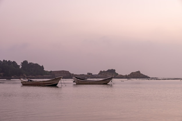 À la ferme d'algues avant le lever du soleil le matin, il y a des rangées d'algues et des bateaux