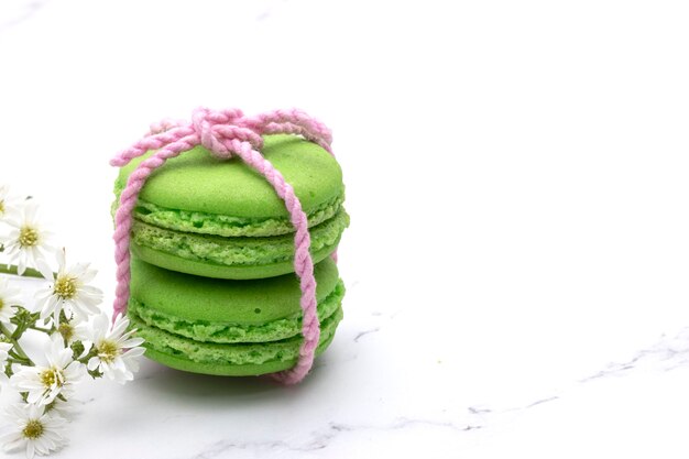 Photo fermé de deux macarons verts sur un fond de marbre