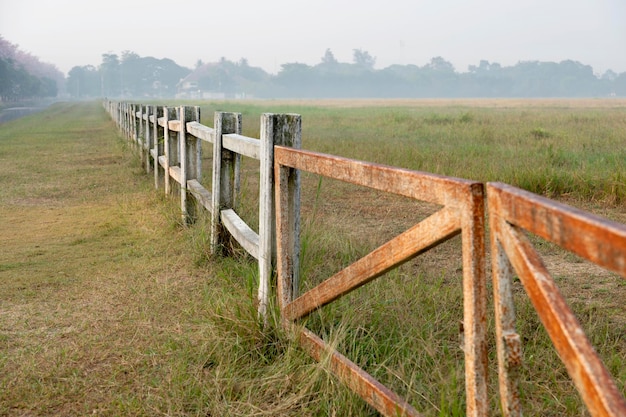 Ferme équestre avec vieille clôture en bois sur pâturage sec de paysage naturel