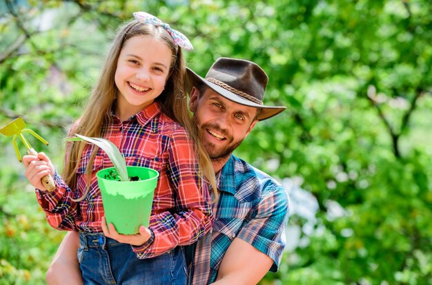 Ferme familiale agriculture printemps village pays écologie environnement sols et engrais petite fille et papa heureux jour de la terre nouvelle vie père et fille au ranch Prendre bien soin des plantes