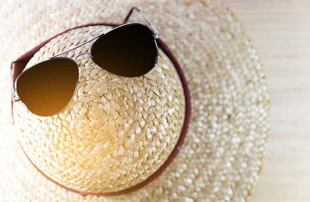 Photo fermé les lunettes de soleil et chapeau de paille