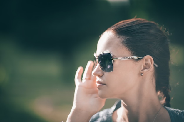 Fermer. belle fille moderne à lunettes de soleil. portrait en plein air