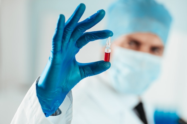 Fermer. capsule avec un vaccin entre les mains d'un scientifique. photo avec un espace de copie.