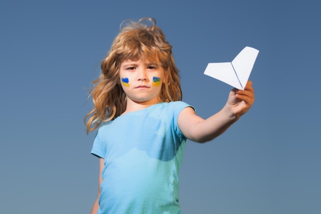 Fermer le ciel au-dessus de la bannière de l'ukraine zone d'exclusion aérienne au-dessus de l'ukraine drapeau de l'ukraine sur la joue des enfants