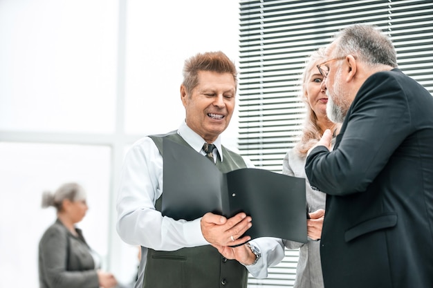 Fermer. employés expérimentés de l'entreprise discutant de documents commerciaux. bureau en semaine