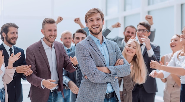 Fermer. des employés joyeux de l'entreprise applaudissent leur collègue.