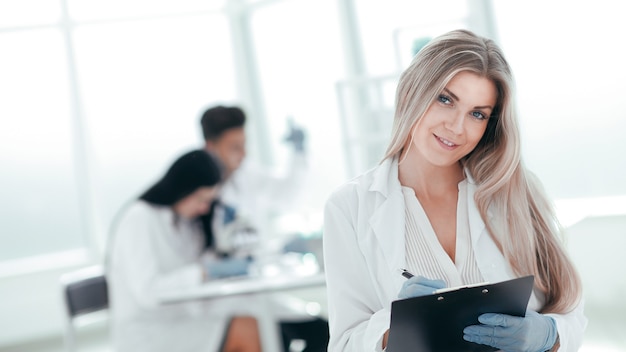 Fermer. femme scientifique prenant des notes sur le presse-papiers. photo avec espace copie